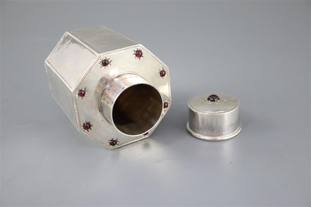 A George V Liberty & Co silver and nine stone cabochon garnet set octagonal tea caddy and cover,